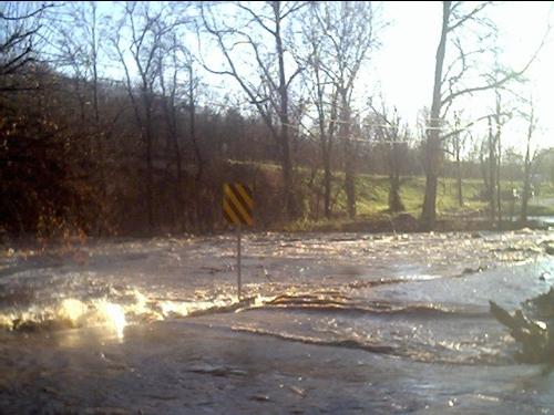 Flood - The other day we had quite a lot of rain and it made the creek flood. This is a picture my Mother took at the end of our road. There -used- to be a bridge there. Bet you can't tell that by looking at this picture though.