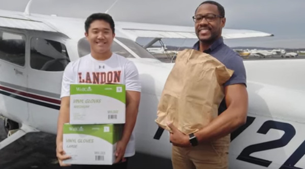 TJ Kim and another person in front of a small plane. TJ Kim and another person in front of a small plane.