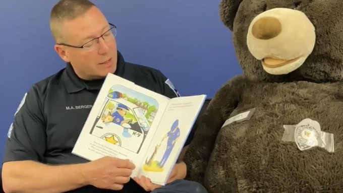 Davenport Sergeant Mark Berger and a mascot reading children's books Davenport Sergeant Mark Berger and a mascot reading children's books