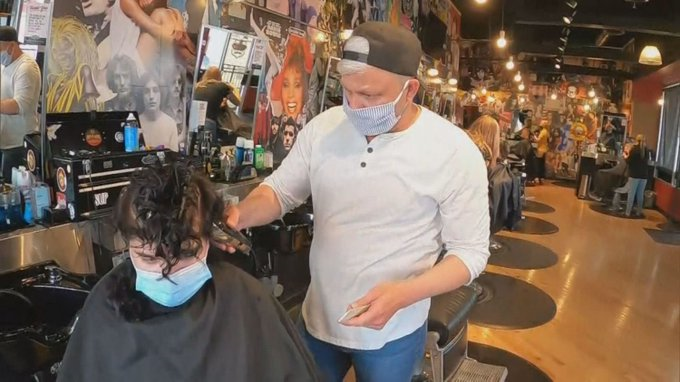 A barber in Denver Colorado cutting the hair of a customer A barber in Denver Colorado cutting the hair of a customer