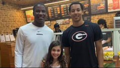 Two Georgia football players and a young girl who is thankful for their kindness Two Georgia football players and a young girl who is thankful for their kindness