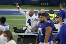 Prescott saluting fans while being carted off