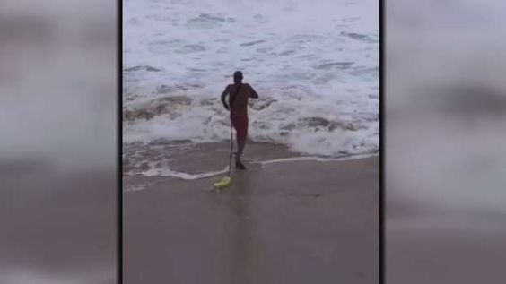 A cellphone showing lifeguard Freddie Booth to the rescue of a swimmer
