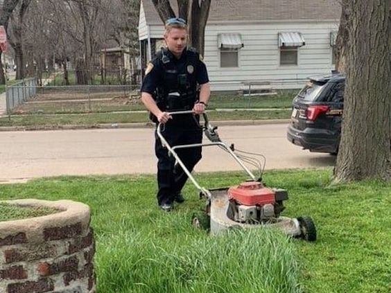 Hutchinson Kansas Police Officer Wells mowing a lawn for a senior lady