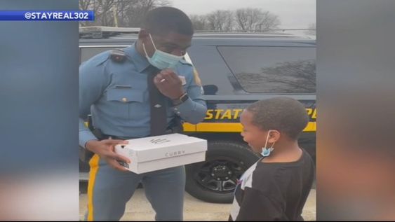 Delaware State Trooper Morris doing a good deed for a young child. Delaware State Trooper Morris doing a good deed for a young child.