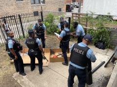 Chicago police officers setting up a basketball hoop for children in their area 
