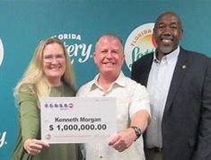 Kenneth Morgan (Middle). his wife (L) and a Florida Lottery Official