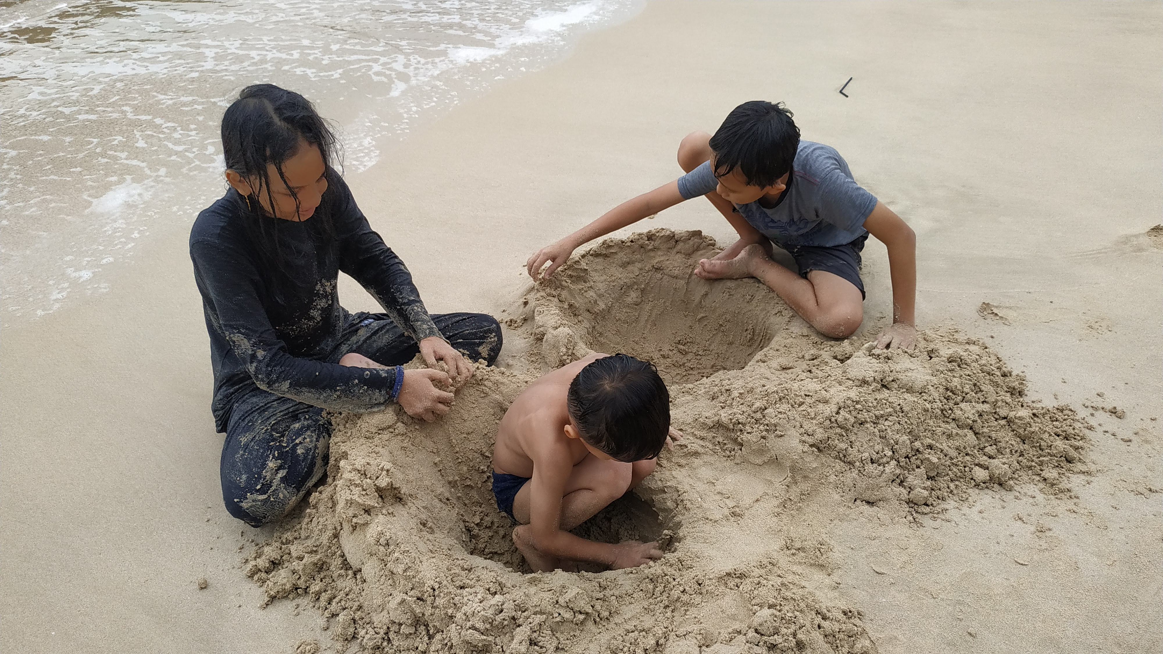 My two children and their cousin played in the sand.