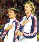 Winners - Shows two athletes with their hands over their hearts obviously listening to their national anthem at the awares ceremony