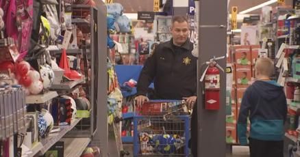 Clay County Sheriff Will Akin with a child doing Christmas shopping on Sunday Clay County Sheriff Will Akin with a child doing Christmas shopping on Sunday