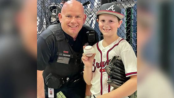 Cobb County police officer Deupree with a young Atlanta Braves fan. Cobb County police officer Deupree with a young Atlanta Braves fan.