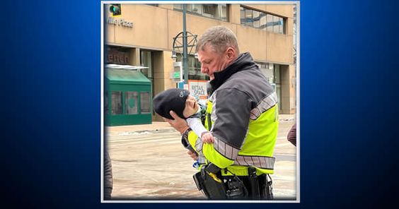 Denver police officer Dada holding an infant in his arms on Thursday Denver police officer Dada holding an infant in his arms on Thursday