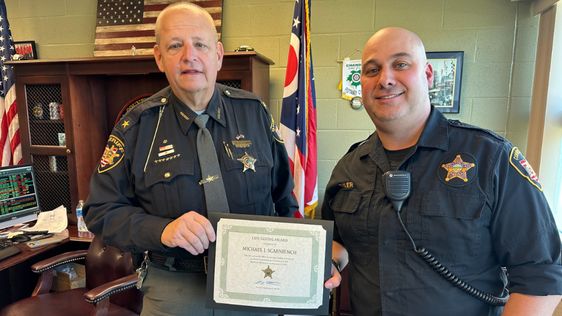 Geauga County Sheriff Scott Hildenbrand (L) presents deputy Michael Scarniech an award in Ohio