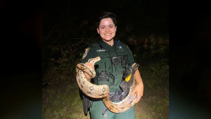 Seminole County Deputy Leguizamo rescuing a snake on a road in Florida. Seminole County Deputy Leguizamo rescuing a snake on a road in Florida.