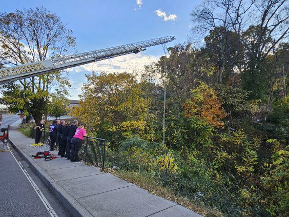 Knoxville Fire Department firefighters rescuing a female who fell down into a creek