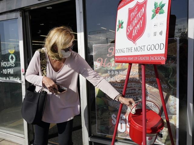 A donor making a donation at a red kettle of the Salvation Army A donor making a donation at a red kettle of the Salvation Army