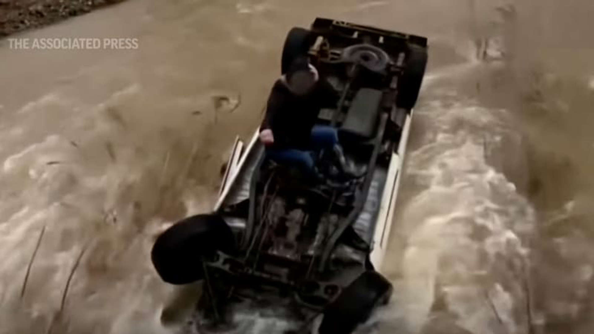 A helicopter in Livermore California rescues a pickup truck stuck in a creek.