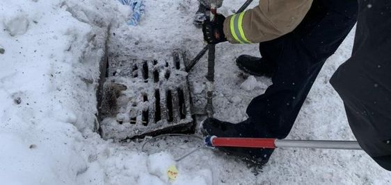 Firefighters in Ontario rescue a raccoon trapped inside of a sewer grate