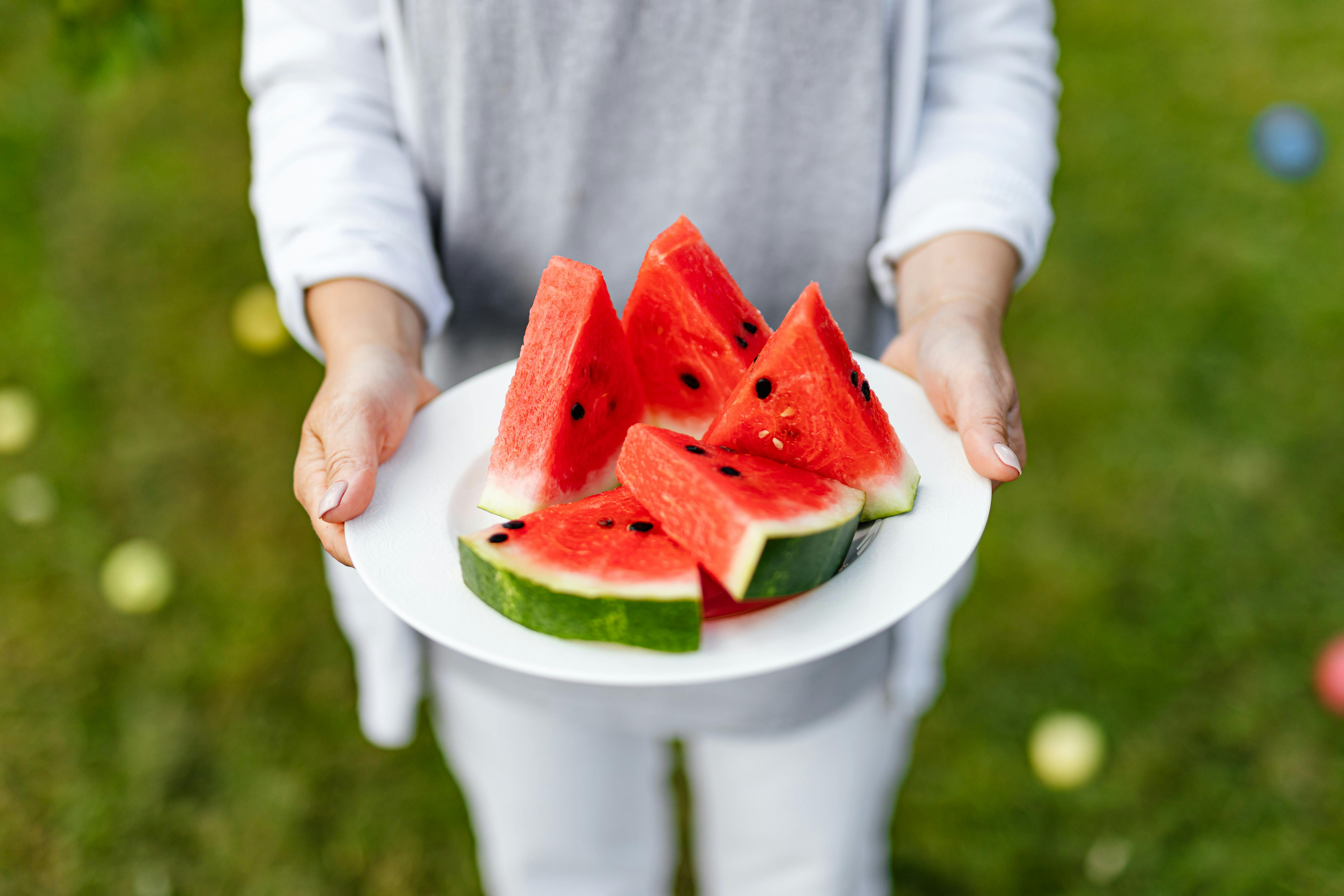 Photo by Karolina Kaboompics: https://www.pexels.com/photo/person-holding-sliced-watermelonwith-seeds-on-white-ceramic-plate-4965566/