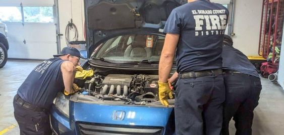 Firefighters remove a marmot from an engine of an auto in California Firefighters remove a marmot from an engine of an auto in California