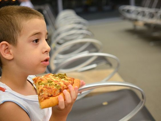 A child at an airport in New Mexico receives a piece of pizza