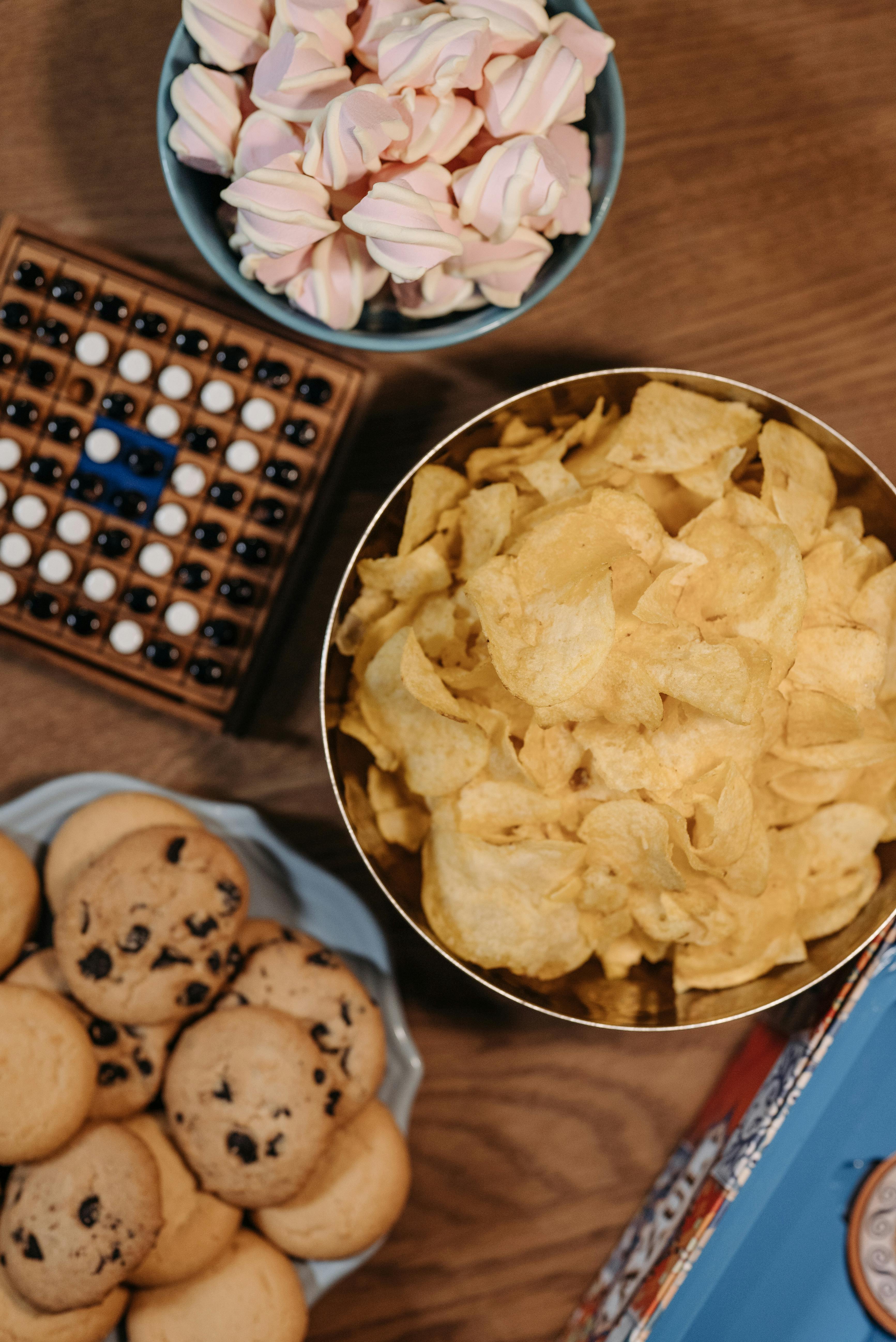 Photo by Pavel Danilyuk: https://www.pexels.com/photo/bowls-of-chips-and-cookies-beside-a-board-game-8111361/