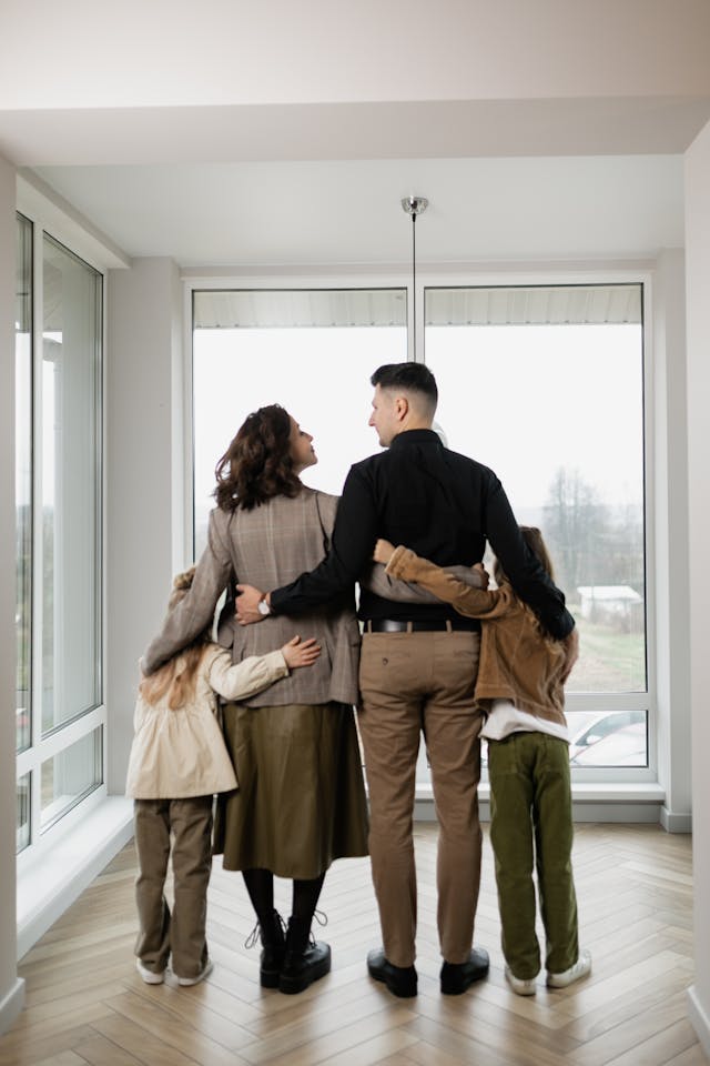 Photo by Alena Darmel: https://www.pexels.com/photo/a-family-standing-near-the-glass-windows-of-the-house-7642038/