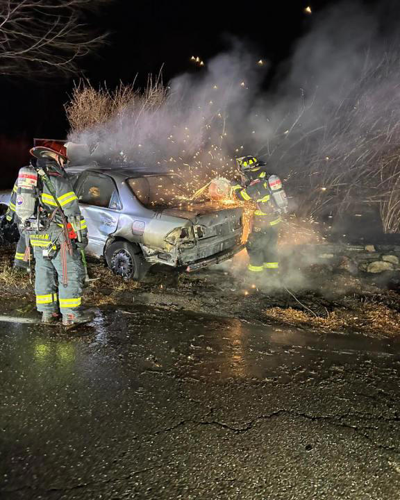 Firefighters in Monroe Connecticut douse a fire from a burning auto on Saturday night. Firefighters in Monroe Connecticut douse a fire from a burning auto on Saturday night.
