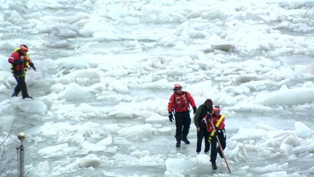 Emergency crew members rescue a man who went walking on a frozen lake. Emergency crew members rescue a man who went walking on a frozen lake.