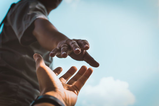An image depicting a person helping another. Source: Adobe Stock