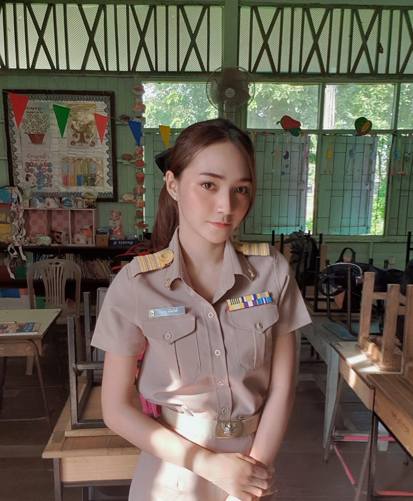 A photo of a Thai teacher wearing a uniform in class. 