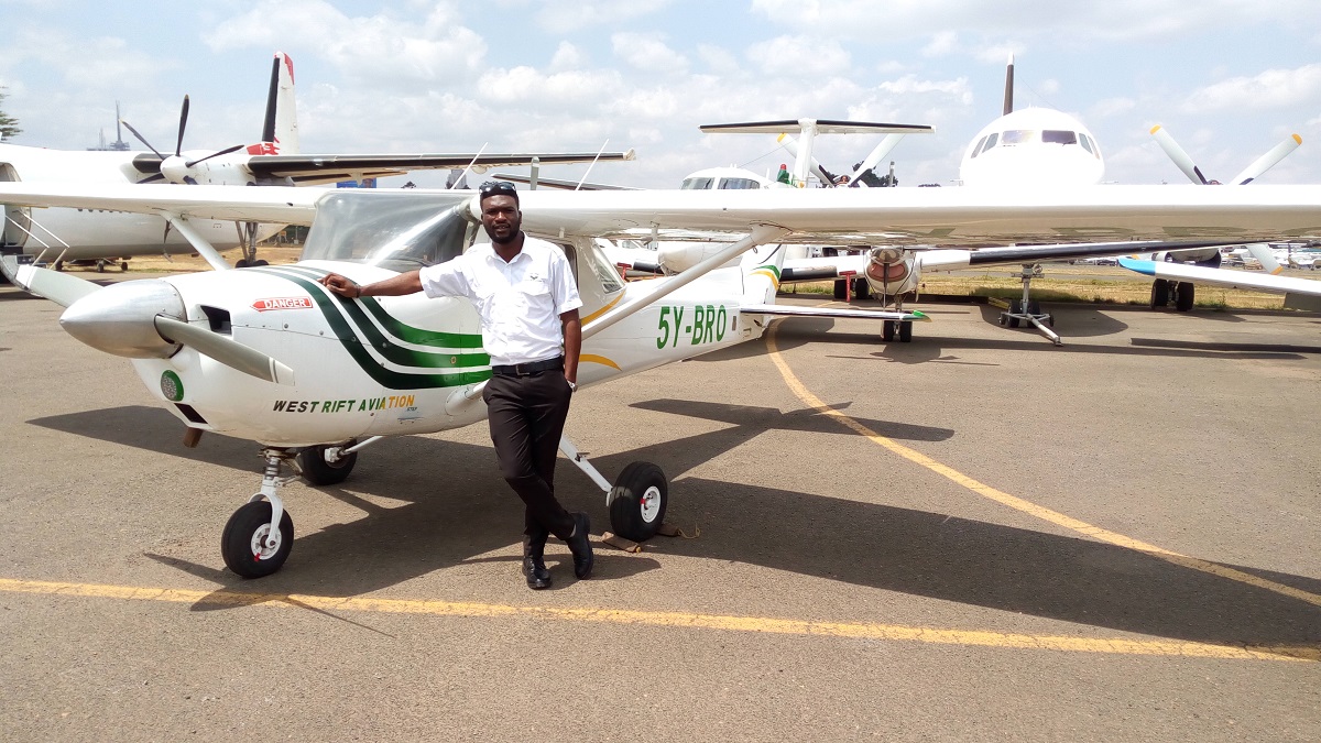An image of a student pilot posing next to small training planes An image of a student pilot posing next to small training planes