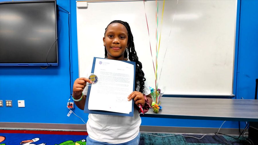 Elementary school student Allison receives an award from the Cleveland Police 