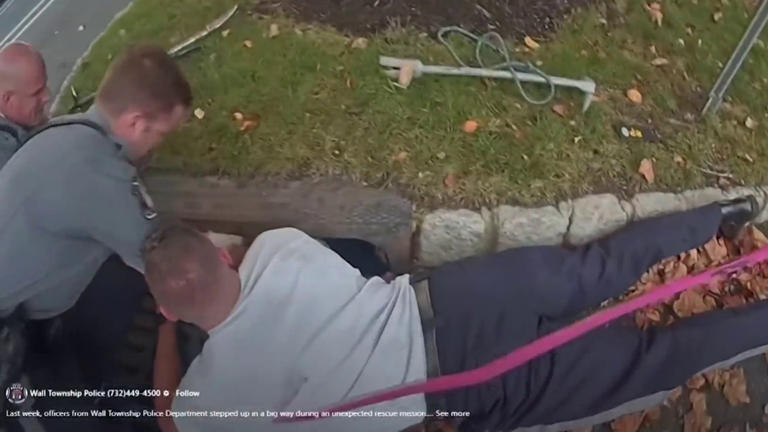 Police officers in Wall Township New Jersey rescue a dog trapped in a storm drain  Police officers in Wall Township New Jersey rescue a dog trapped in a storm drain