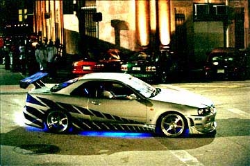 Skyline - This is a picture of a white skyline with blue neon lights on the bottom of the car.