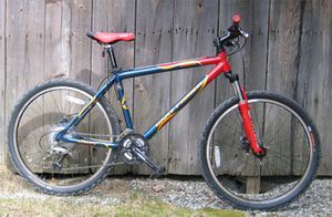 Mountain cycle - This mountain bicycle features oversized tires, a sturdy frame, front shock absorbers, and handlebars oriented perpendicular to the bike's axis. These have allowed for a proliferation of specialized designs for individuals who pursue a particular type of cycling.