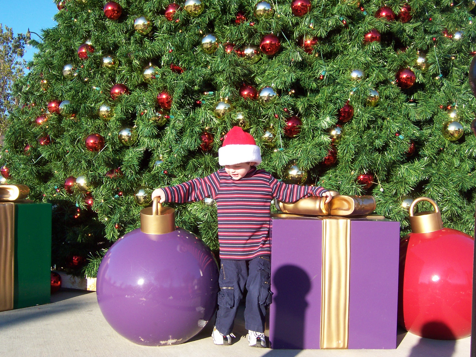 Larger Than Life Christmas Display - This is taken at a huge fresh air shopping center not too far from where I live.  I was so taken by the huge presents and ornaments that I had to take my son's picture next to them.
