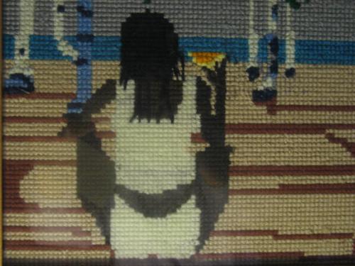 justcurious - Photo of a girl sitting on a beach holding a piece of orange or lemon.  This photo was taken in Hawaii.  It was a portrait hanging on the hotel wall.  It was drawn and traced into a cross-stitch work of art.