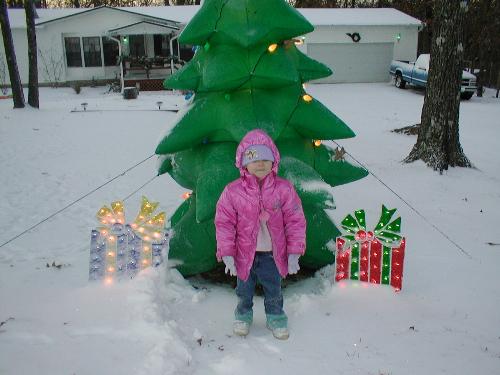 serena in the snow infront of the christmas tree - my daughter