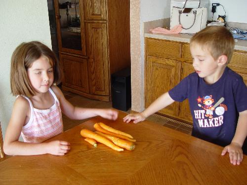 kids with there carrots they planted - ki8ds, they love to have fun and they planted a vegtable garden this year.