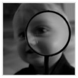 Big Eye - photo of a small child looking through a magnifying glass.