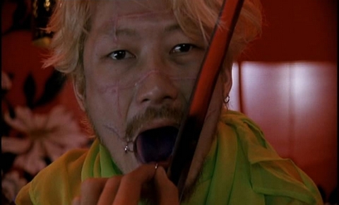 ichi the killer - Ichi the Killer (2001) (also Koroshiya Ichi) is a highly controversial film directed by Takashi Miike and adapted from a manga by Hideo Yamamoto.  The film stars Tadanobu Asano as Kakihara, a sadomasochist yakuza enforcer who enjoys giving and receiving pain in about equal measures. To reinforce this, he is shown as having his mouth widened on both sides by several inches, with his cheeks held together with piercings. Kakihara's boss Anjo vanishes one night after he is murdered in a particularly gruesome fashion. A mysterious group arrives and cleans up all evidence of the murder, and takes the three million yen (roughly $25 850 US) Anjo had in his room.  Many of Kakihara's compatriots, including Anjo's English and Chinese-speaking girlfriend Karen (Alien Sun), suspect that Anjo simply took the money and ran, but Kakihara is convinced the man is alive. His investigation leads him to brutally torture a member of a rival clan, Suzuki (Susumu Terajima) by suspending him from a ceiling by putting metal hooks through the man's back, shoving stilettos through his body, and throwing boiling grease (from a meal of tempura) on him. (In an example of the film's extremely black humor, when asked what he is doing, Kakihara responds nonchalantly, 'Just a little torture, nothing special.')  The man turns out to be innocent. To make restitution, Kakihara slices off part of his tongue and offers it to Suzuki's boss (Jun Kunimura). However, the man who tipped Kakihara off to Suzuki and may have more real information, a disheveled old man nicknamed Jijii (Shinya Tsukamoto), is nowhere to be found.  Jijii is, as it turns out, secretly orchestrating events. Under his wing is a young man, Ichi (Nao Omori), a confused and apparently psychotic individual who is normally unassuming and cowardly, but becomes homicidal when enraged (and who has crying fits when committing his murders). Ichi outfits himself in a rubber suit with shoes that have razors concealed in the heels, and after spying on a pimp brutalizing a prostitute kills first the pimp, then the girl. Jijii has so manipulated Ichi as to confuse sexual arousal with homicidal lust in him, and accomplished this by creating a false memory in him of witnessing a rape in high school -- which he felt ashamed for wanting to participate in rather than stop.  Kakihara is eventually thrown out of the syndicate for his transgressions, but not before catching word of Ichi. He becomes fascinated with this 'total sadist,' since perhaps through him he can finally find the ultimate pain he has been seeking -- one which neither his girlfriend nor his boss could give him. In a related plot development, Jijii attempts to get better control over Ichi by having Karen seduce him, but the plan backfires horribly and Karen is slaughtered.  Kakihara, along with two corrupt police-detective twin brothers, finds a prostitute connected with Jijii's gang. In one of the film's more disturbing scenes, they torture her for information (primarily by cutting her nipples off). They find one of Jijii's henchmen and torture him to find out where Ichi is. However, at this point Ichi shows up at Kakihara's compound. Ichi and Kakihara eventually confront each other on a rooftop. The film then ostensibly departs from literal reality and gives us a showdown that appears to take place in the minds of one or the other of the main characters, but it remains deliberately obscure which.