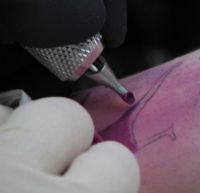 tattoo - It is commonly believed that the original root word of 'tattoo' comes from the Samoan or the Tahitian word tatau, meaning to mark or strike twice (the latter referring to traditional methods of applying the designs).[1] The first syllable 'ta', meaning 'hand', is repeated twice as an onomatopoeic reference to the repititive nature of the action, and the final syllable 'U' translates to 'color'.[citation needed] The instrument used to pierce the skin in Polynesian tattooing is called a hahau, the syllable 'ha' meaning to 'strike or pierce'.[citation needed] (This is not to be confused with the origins of the word for the military drumbeat — see military tattoo.)