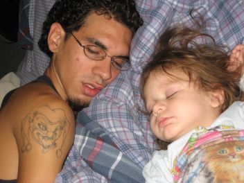 My two favorite people. - This is my boyfriend Hector, and my daughter Karissa Angel sleeping soundly, just the way I like it!  When they are together like this, all I want to do is stay quiet so I don`t wake them up.  They are also both very grumpy when they wake up, together or not!  I love that tattoo too!