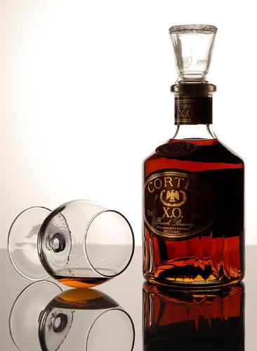 CORTE BRANDY - The origins of brandy are unclear, and tied to the development of distillation. Concentrated alcoholic beverages were known in ancient Greece and Rome and may have a history going back to ancient Babylon. Brandy as it is known today first began to appear in the 12th century and became generally popular in the 14th century.  Initially wine was distiled as a preservation method and as a way to make the wine easier for merchants to transport. It was also thought that wine was originally distilled to lessen the tax which was assessed by volume. The intent was to add the water removed by distillation back to the brandy shortly before consumption. It was discovered that after having been stored in wooden casks, the resulting product had improved over the original distilled spirit. Also, the distillation process doesn't just remove water, but leads to the formation and break-up of dozens of aroma compounds fundamentally altering the composition of the distillate. This is why unaged wine spirits (unaged brandy) diluted back to wine alcohol strength tastes nothing like the original wine