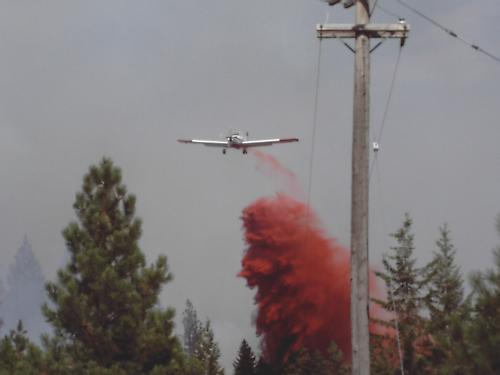 Retardent plane saving a house!!! - Im am a wildland firefighter in the summer. This is a picture of a retardent plane out of Couerd'alene Idaho, that we called to help stop a fast moving fire that was heading for a beautiful house.