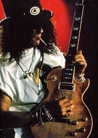 Slash and Guitar Gibson - As the lead guitarist for Guns N' Roses , Slash established himself as one of hard rock's finest and most soulful soloists during the late '80s, technically adept yet always firmly grounded in the gritty Aerosmith and Stones ' licks he loved. Slash was born Saul Hudson on July 23, 1965 in Stoke-on-Trent, England, to artistic parents both involved in the entertainment industry; his mother was a clothing designer who worked on David Bowie 's film The Man Who Fell to Earth , and his father designed album art for such artists as Neil Young and Joni Mitchell . The family eventually moved to Hollywood, where Hudson attended junior high, received his first guitar, and met future GN'R drummer Steven Adler . With Hudson adopting the nickname Slash, given to him by a family friend, the two formed a band called Road Crew ; although it proved unsuccessful, it was the vehicle through which they met and eventually joined up with the other members of Guns N' Roses .