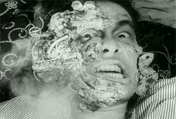 tetsuo - Tetsuo: The Iron Man is a 1988 Japanese film by cult-film director Shinya Tsukamoto. This, his third film, is an extremely graphic but also strikingly-filmed fantasy shot in the same low-budget, underground-production style as his first two films. Tetsuo established Tsukamoto internationally and created his worldwide cult. It was followed by Tetsuo II: Body Hammer. The film opens with a man (called only'the man', or sometimes the'Metals Fetishist') tearing open a massive gash in his leg and shoving in a piece of scrap metal. Upon seeing maggots festering in the wound, he screams, runs out into the street, and is hit by a car. The driver of the car (cult actor Taguchi Tomorowo) tries to cover up the mess by dumping the body into a ravine, but the dead man comes back to haunt him -- by forcing his body to gradually metamorphose into a walking pile of scrap metal. In one of the film's most controversial sequences, the man discovers his pnis has mutated into a gargantuan power drill, and his girlfriend willingly copulates to death upon it. The film ends with a duel between the man and the Fetishist with the pair transformed into a giant mutated monster. One of the main themes of the movie is the main character's latent homosexuality. Some critics have seen this film as being a literal use of a metaphor, showing mankind's dehumanization and'becoming the machine'. The scene involving the businessman killing his girlfriend with his own pnis-turned-powerdrill is indicative of the dehumanization. The setting, which shows modern Japan as an industrial wasteland, suggests a post-apocalyptic nightmare. Some critics have suggested that Shinya Tsukamoto was making a statement on the dehumanization of industrialized Japan and the Japanese corporate culture. The film can also be seen as a comment on impotence as a metaphor for the feeling of alienation and helplessness in the face of byzantine corporate culture and modern urban life. The main character 'salary man' and his wife react with sexual arousal after they run over the metal fetishist, and the salary man is very different after the appearance of his'power tool pnis' from his former corporate-puppet-self. It is suggested that this state of virility is different from before the hit and run accident. The iron/machine-mutation comes to represent personal empowerment, with both good and bad sides to it. This is even further underscored by the shape of the mutated creature which appears at the end of the film, which is more than a bit similar to an erect pnis. It has been often discussed that Tetsuo is a metaphor for the spread of the AIDS virus. The film is Unrated but contains substantial strange violent and sexual imagery. The film is also discussed in Clive Barkers'A-Z Book of Horror'. The DVD has been released in America and elsewhere from Tartan Asia Extreme.