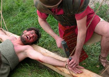 The Crucifixion - A volunteer grimaces for the camera during filming for 'The Quest for Truth: The Crucifixion,' airing Sunday. The volunteer was tied to a cross to study the biomechanics of crucifixion, but no one was actually hurt. The simulated nailing was just for show.