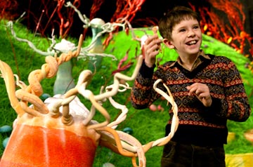Charlie and the Chocolate Factory  - Most nights in the Bucket home, dinner is a watered-down bowl of cabbage soup, which young Charlie gladly shares with his mother and father and both pairs of grandparents. Every night, the last thing Charlie sees from his window is Willy Wonka's great factory, and he drifts off to sleep dreaming about what might be inside. For nearly fifteen years, no one has seen a single worker going in or coming out of the factory, or caught a glimpse of Wonka himself, yet, great quantities of chocolate are still being made and shipped all over the world. One day Willy Wonka makes a momentous announcement. He will open his famous factory and reveal 'all of its secrets and magic' to five lucky children who find golden tickets hidden inside five randomly selected Wonka chocolate bars. Nothing would make Charlie's family happier than to see him win but the odds are very much against him as they can only afford to buy one chocolate bar a year, for his birthday. One by one, news breaks around the world about the children finding golden tickets and Charlie's hope grows dimmer. But then, something wonderful happens. Charlie finds some money on the snowy street and takes it to the nearest store for a Wonka Whipple-Scrumptious Fudgemallow Delight. There, under the wrapper is a flash of gold. It's the last ticket. Charlie is going to the factory! The family decides that Grandpa Joe, who used to work in the factory, should be the one to accompany Charlie on this adventure. Once inside, Charlie is dazzled by one amazing sight after another. Wondrous gleaming contraptions of Wonka's own invention churn, pop, and whistle, crews of merry Oompa-Loompas mine mountains of fudge beside a frothy chocolate waterfall, a hundred trained squirrels on a hundred tiny stools shell nuts for chocolate bars, and Wonka himself pilots an impossible glass elevator that rockets every which way you can think of through the fantastic factory. Almost as intriguing as his fanciful inventions is Willy Wonka. He thinks about nothing but candy--except, every once in a while, when he seems to be thinking about something that happened long ago, that he can't quite talk about. Meanwhile, the other children prove to be a rotten bunch, and one by one, their greedy personalities lead them into all kinds of trouble that force them off the tour. When only Charlie is left, Willie Wonka reveals the final secret, the absolute grandest prize of all: the keys to the factory itself.